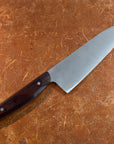 Chef's knife with a brown handle on a brown surface
