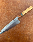 Chef's knife with wooden handle on a brown surface