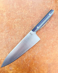 Chef's knife with a decorative handle on a wooden surface