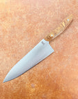 Chef's knife with wooden handle on a brown surface
