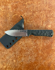 Knife with a black sheath on a brown surface Uinta