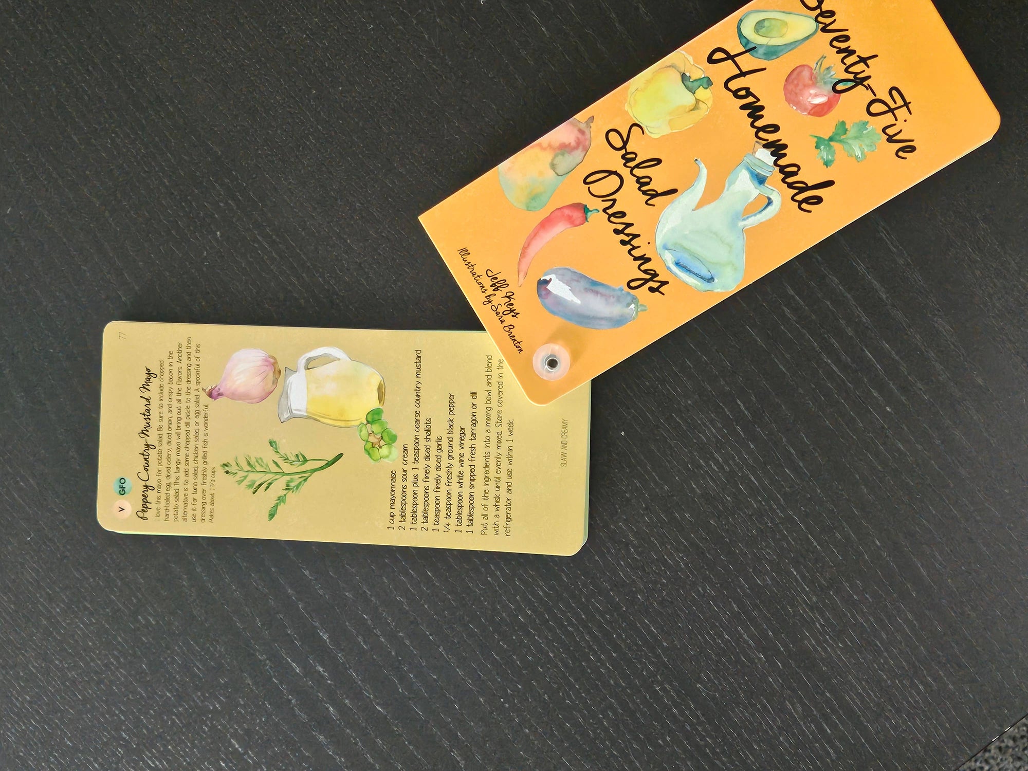 Two decorative labels with illustrations and text on a dark surface