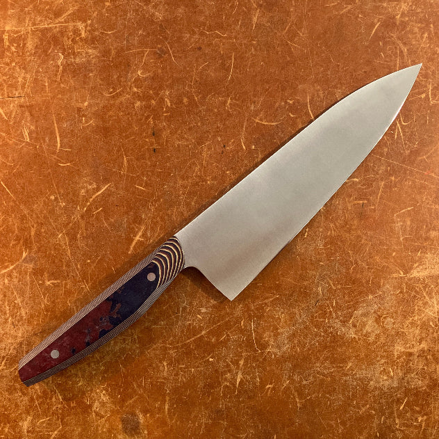 Chef's knife with a decorative handle on a brown surface
