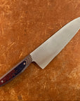 Chef's knife with a decorative handle on a brown surface