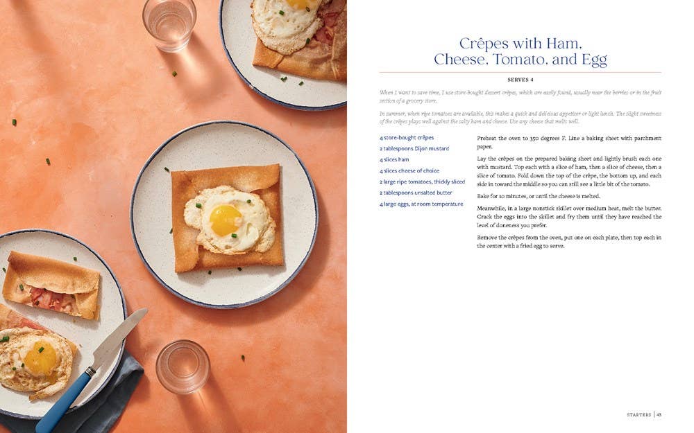 Crepés with Ham, Cheese, Tomato, and Egg on a plate with a knife and glasses on an orange surface.