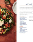 Platter of salad with a wreath shape on a red-tiled surface, next to a magazine page with text.