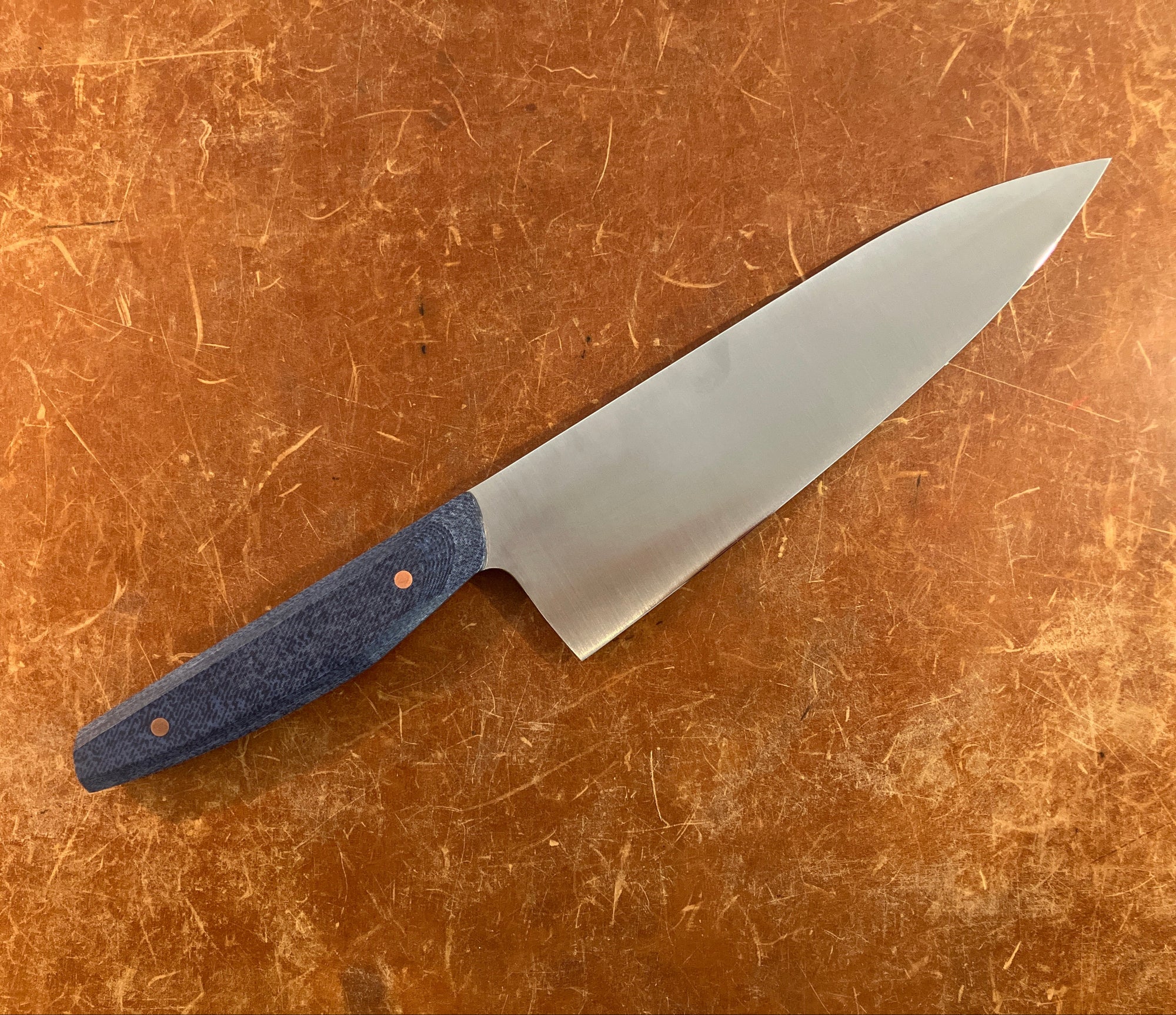 Knife with a blue handle on a brown surface