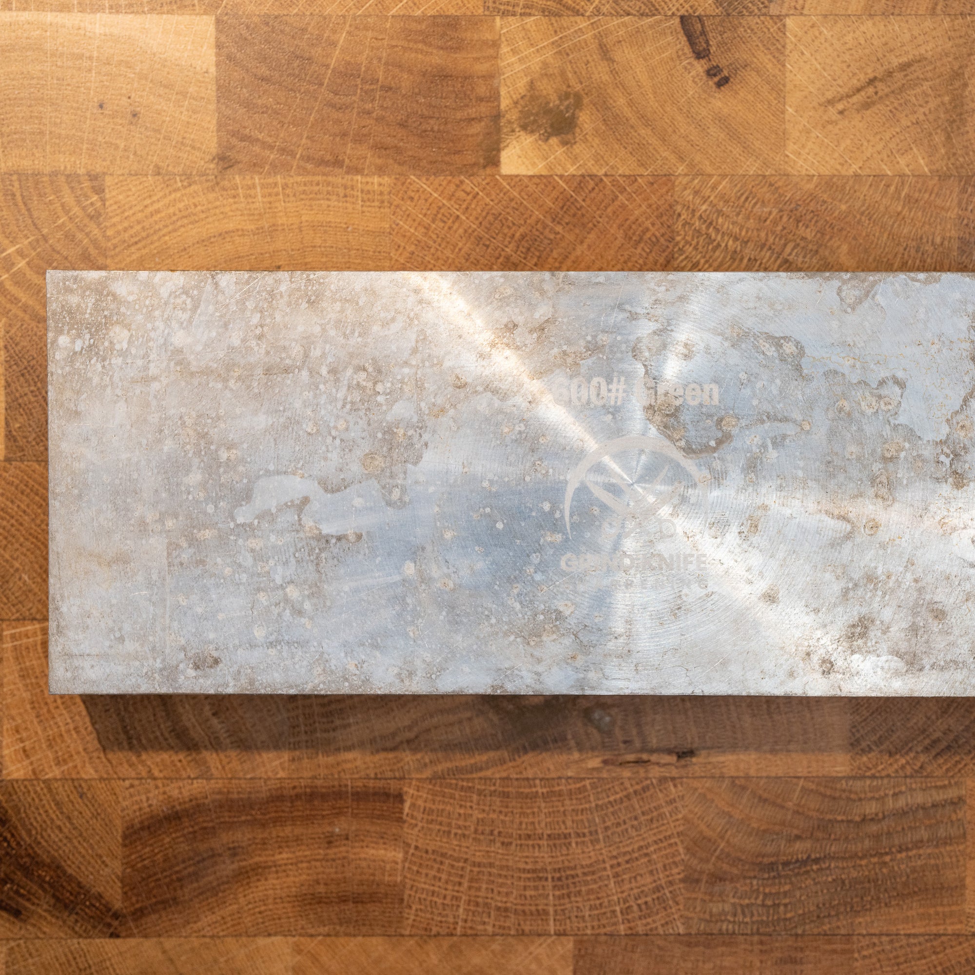Metal slab back of a diamond resin sharpening stone 600 on a wooden surface