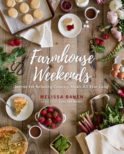Book cover of 'Farmhouse Weekends' with a rustic wooden table setting featuring food and flowers.