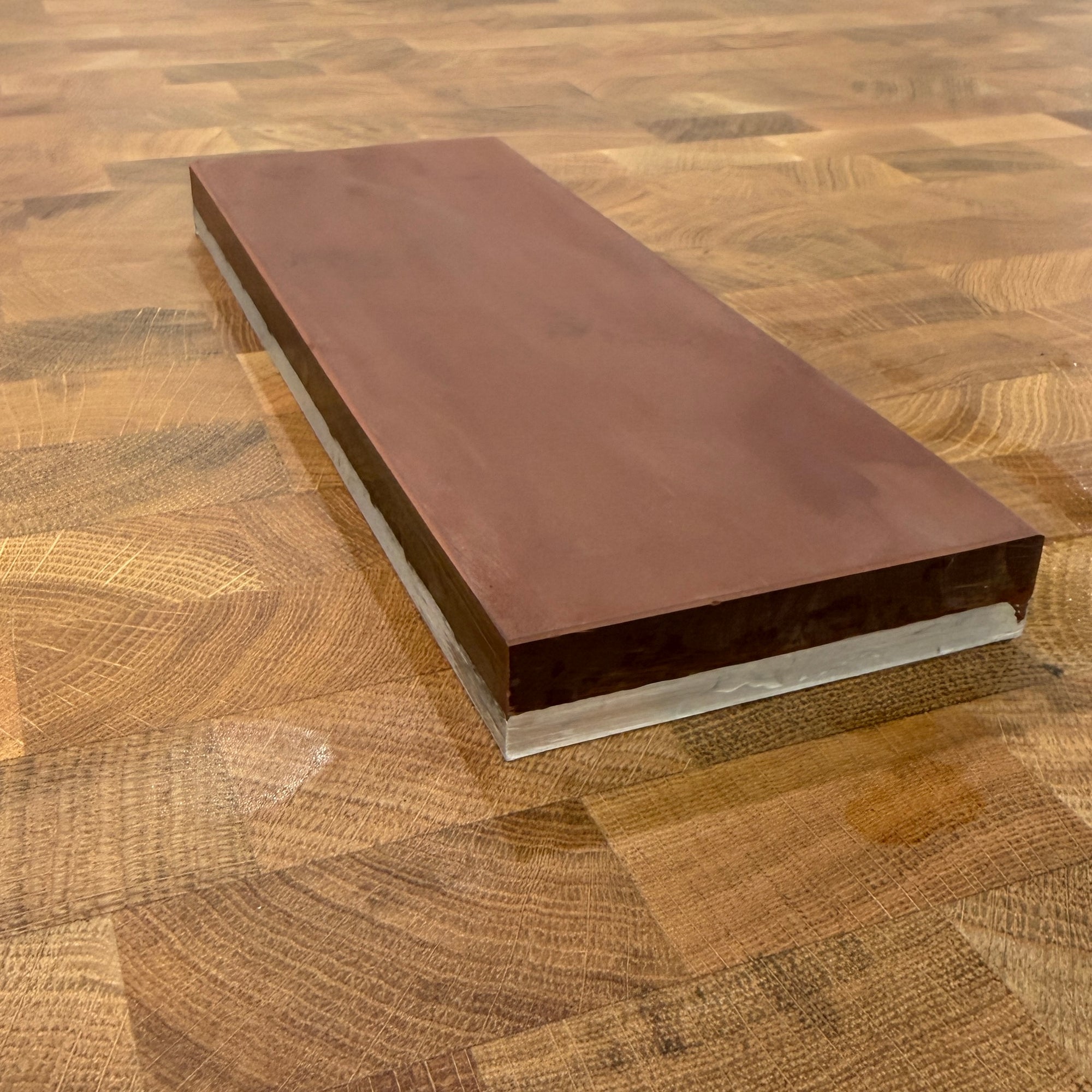 Rectangular metal object - stone - on a wooden surface