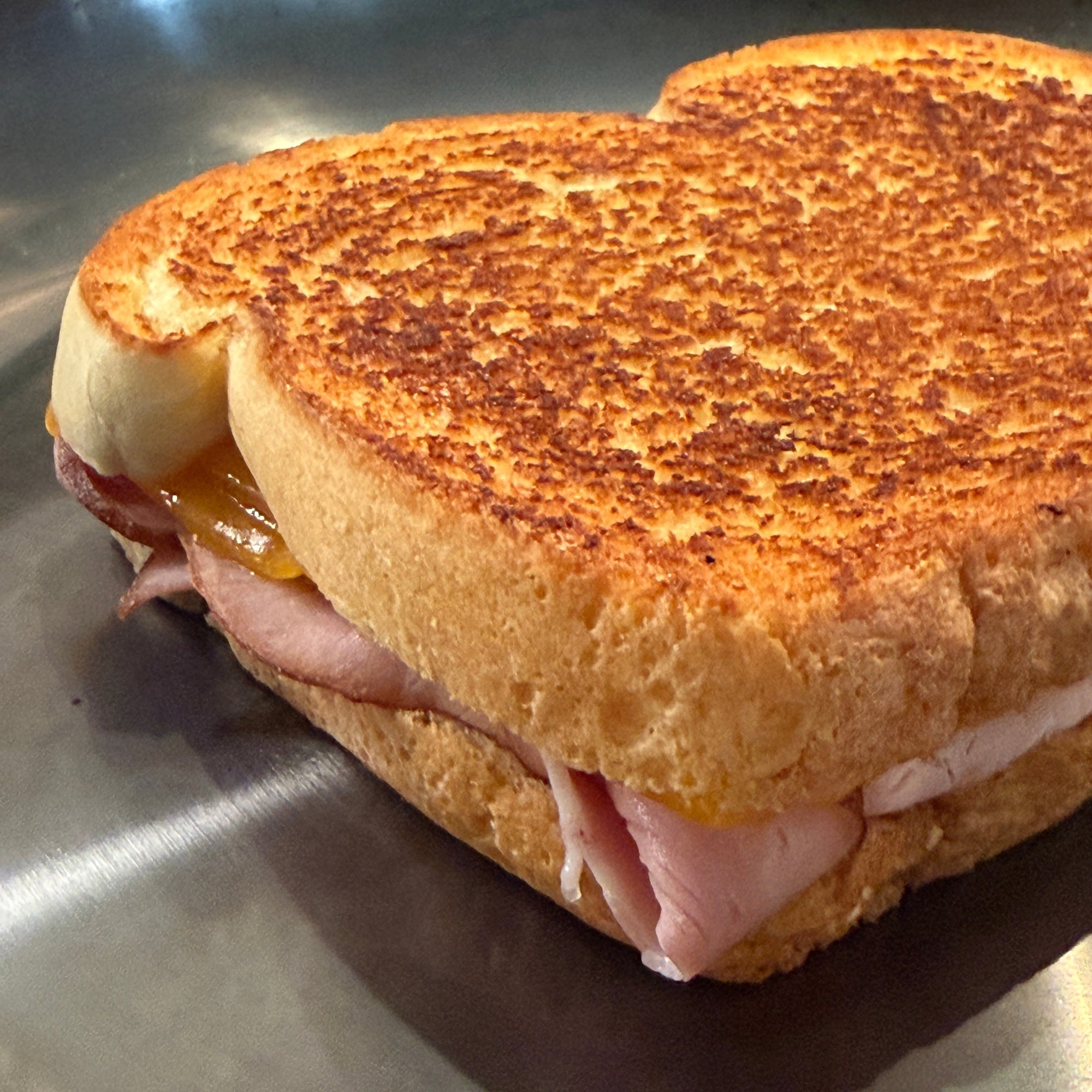 Sandwich with toasted bread on a metallic surface hestan pan cooked with chef press