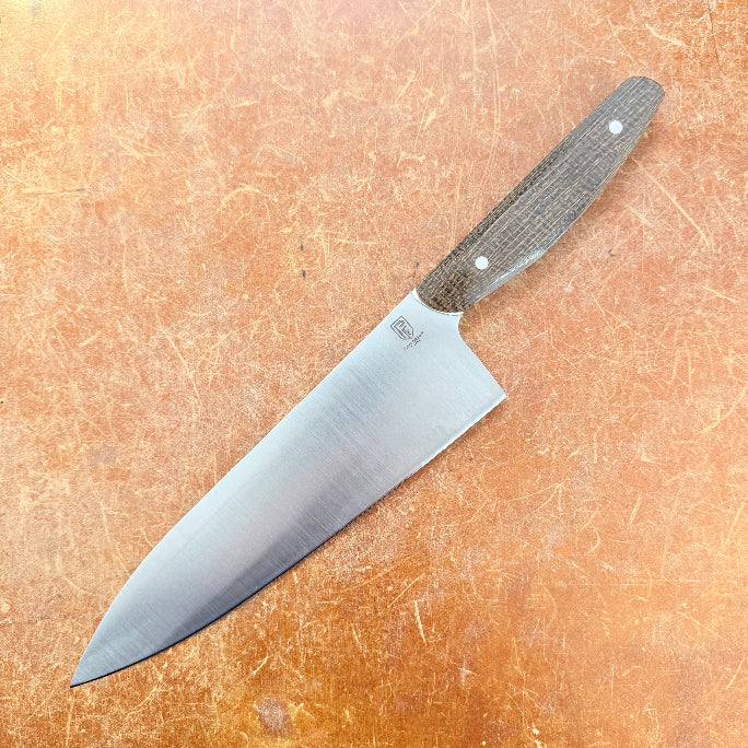 Chef's knife with a wooden handle on a brown surface