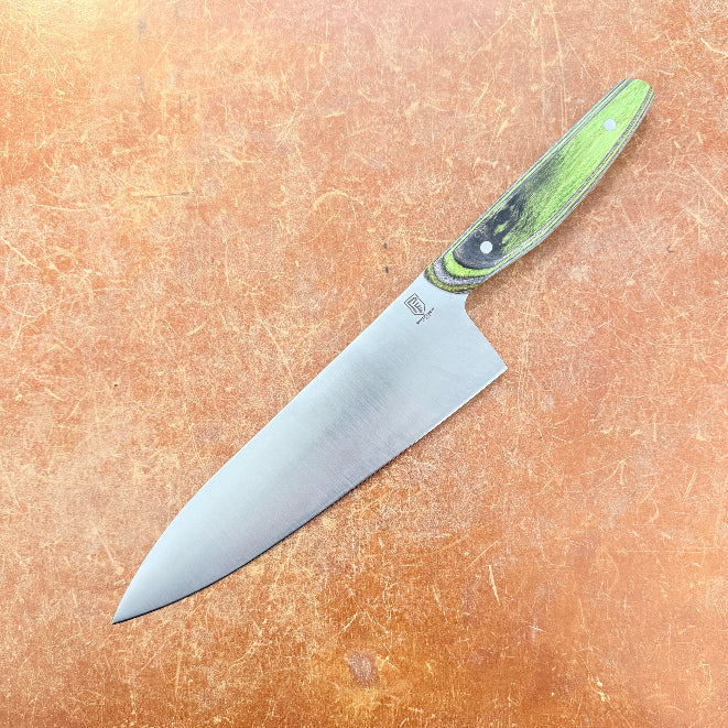 Chef's knife with a green handle on a brown surface
