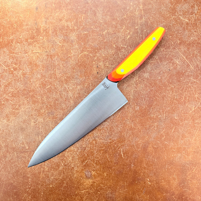 Chef's knife with a colorful handle on a brown surface