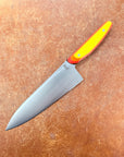 Chef's knife with a colorful handle on a brown surface