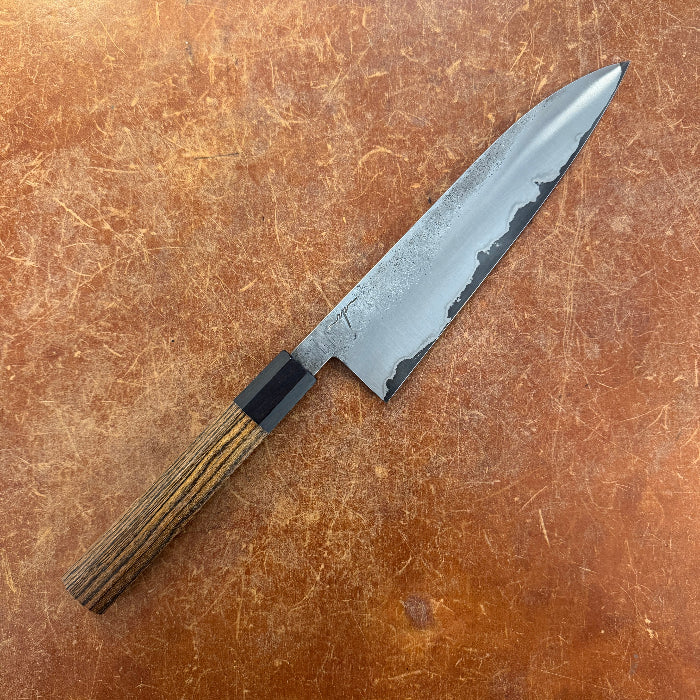 Chef's knife with a wooden handle on a brown surface