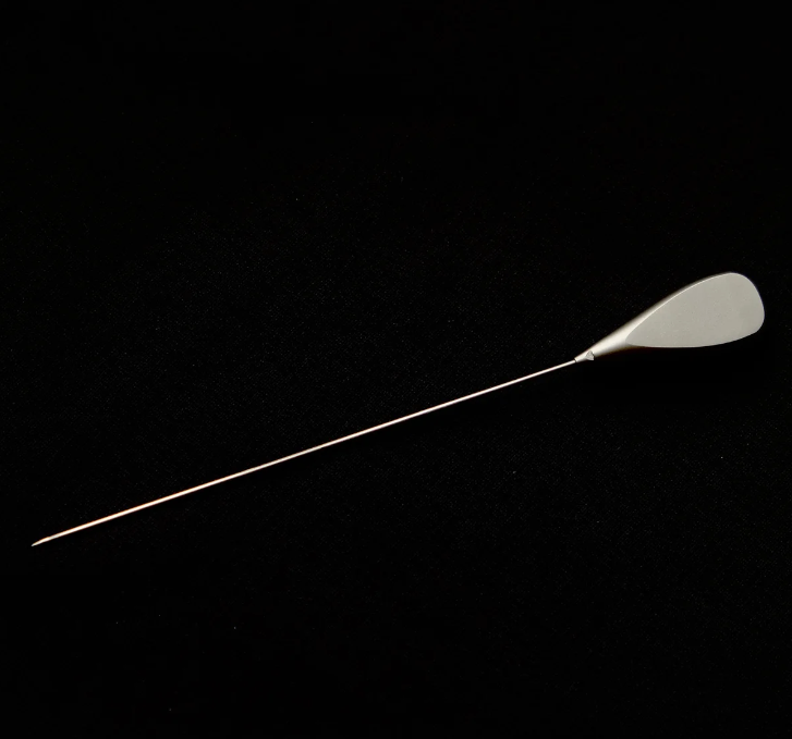 Long thin metallic object on a black background