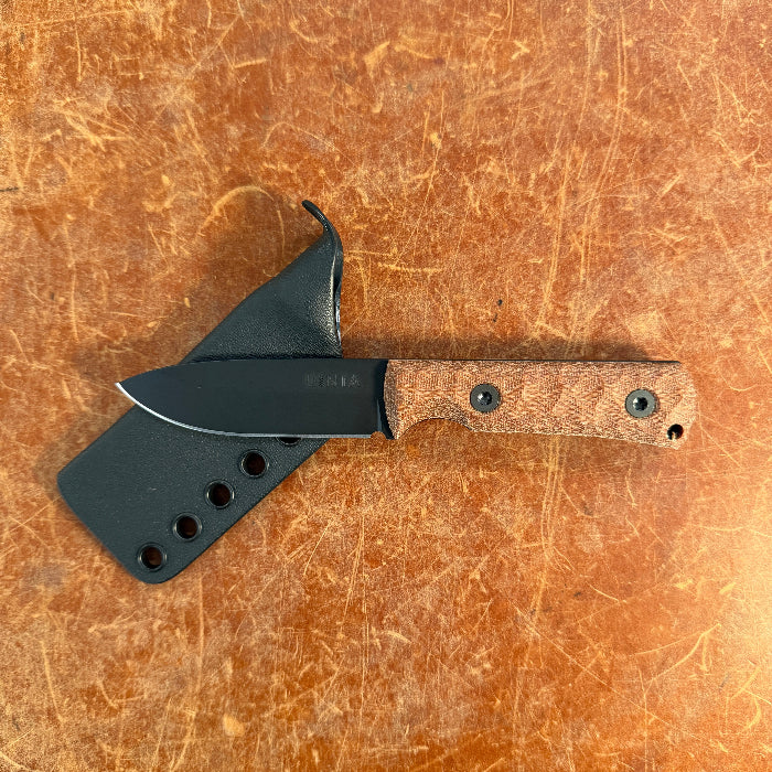 Knife with a wooden handle on a brown leather background uinta