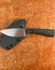 Knife with a black handle and silver blade on a brown surface  Uinta