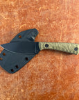 Knife with a black sheath on a brown leather surface Uinta