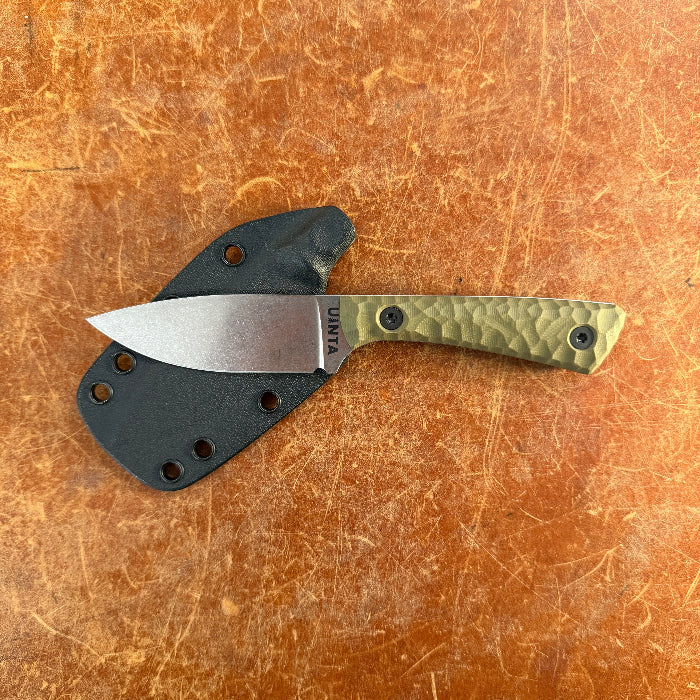 Knife with a black sheath on a brown surface Uinta