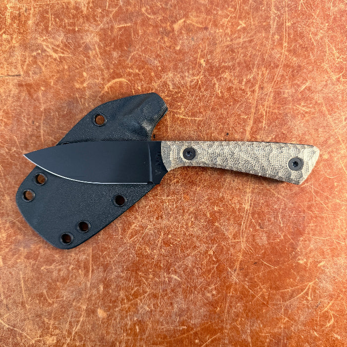 Knife with a black sheath on a brown surface