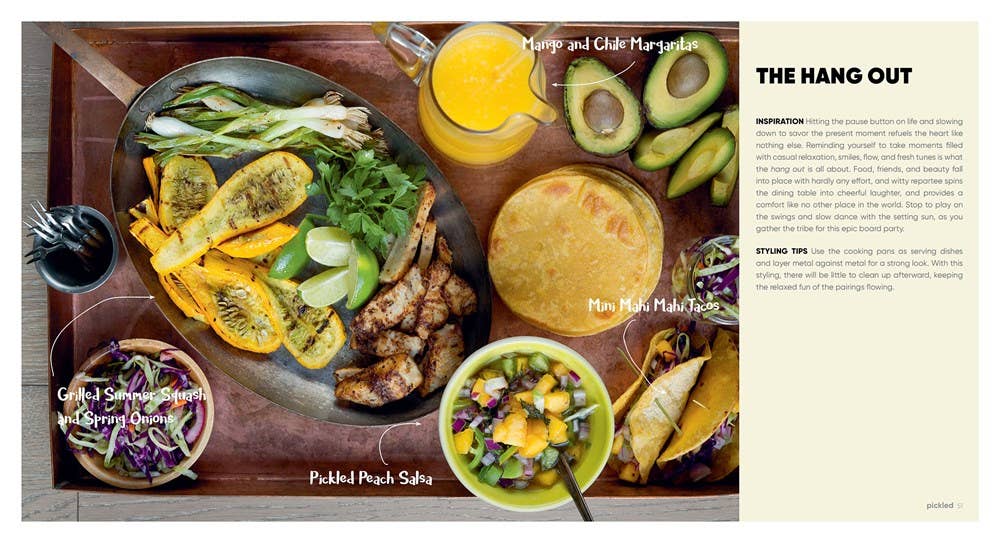 Platter of food with drinks on a wooden tray, including chicken, vegetables, and a mango and chili margarita.